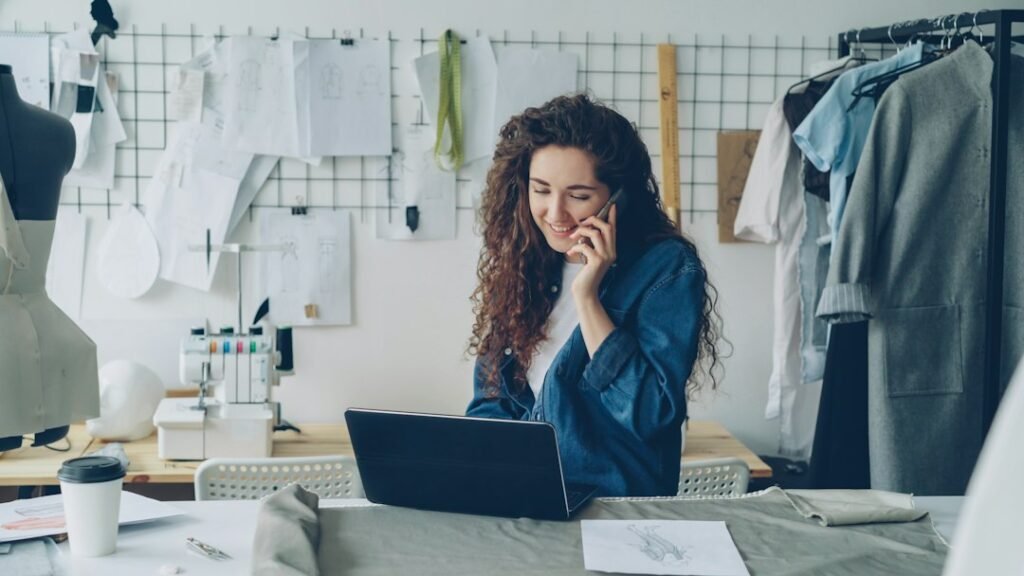 Tailor shop owner on a laptop reviewing small business website cost and quotes