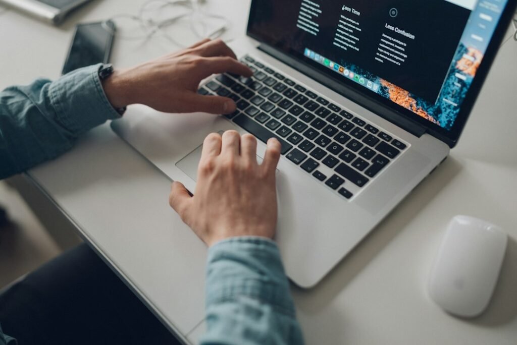 Person working on a laptop reviewing what is a landing page for an ad campaign